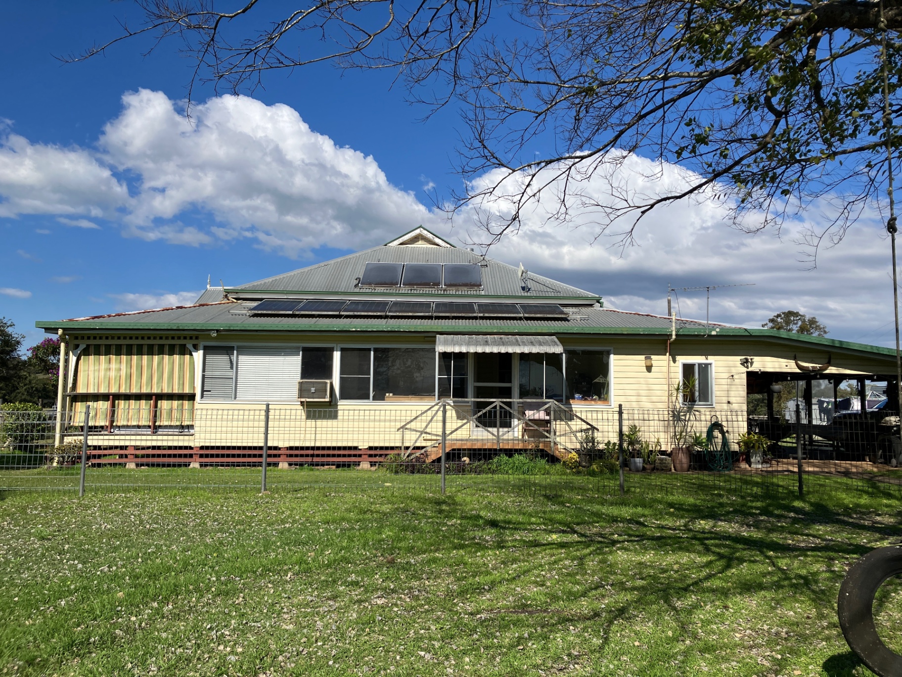 A weatherboard cottage in the Northern Rivers, surrounded by garden and tall trees